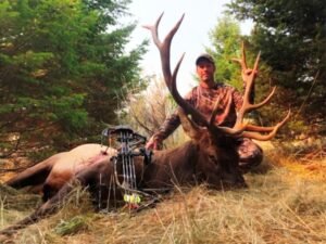 An archery hunter at Elk Ridge Outfitters posing with his kill